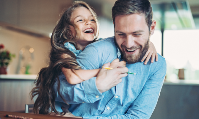 A small girl playing with her father