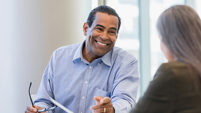 A real estate agent in meeting with client and smiling