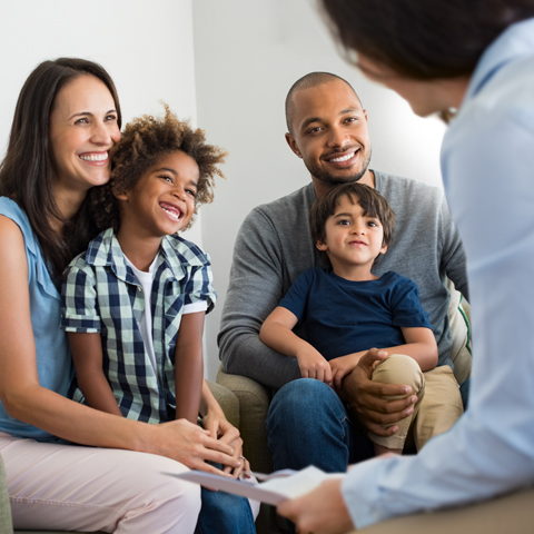 Real Estate Agent in Discussion with a Happy Family