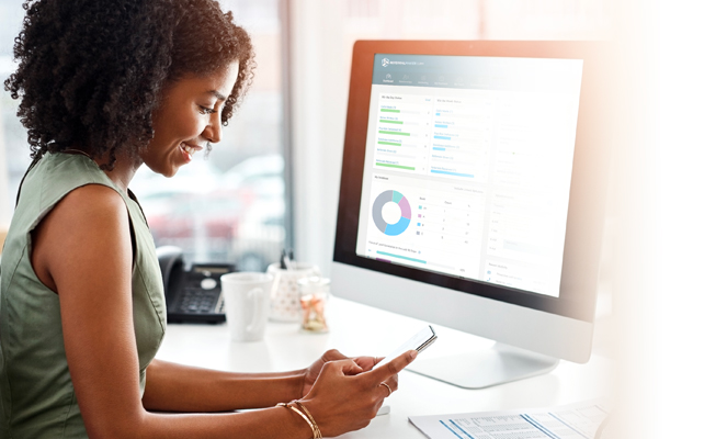 Woman Working on a Computer and Smartphone Simultaneously