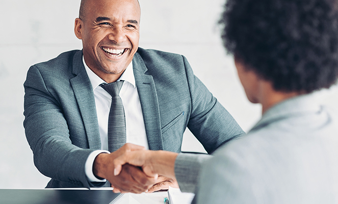 Smiling Real Estate Agent Shaking Hand with Customer